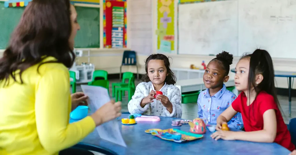 Happy Days Curriculum with children sitting around table